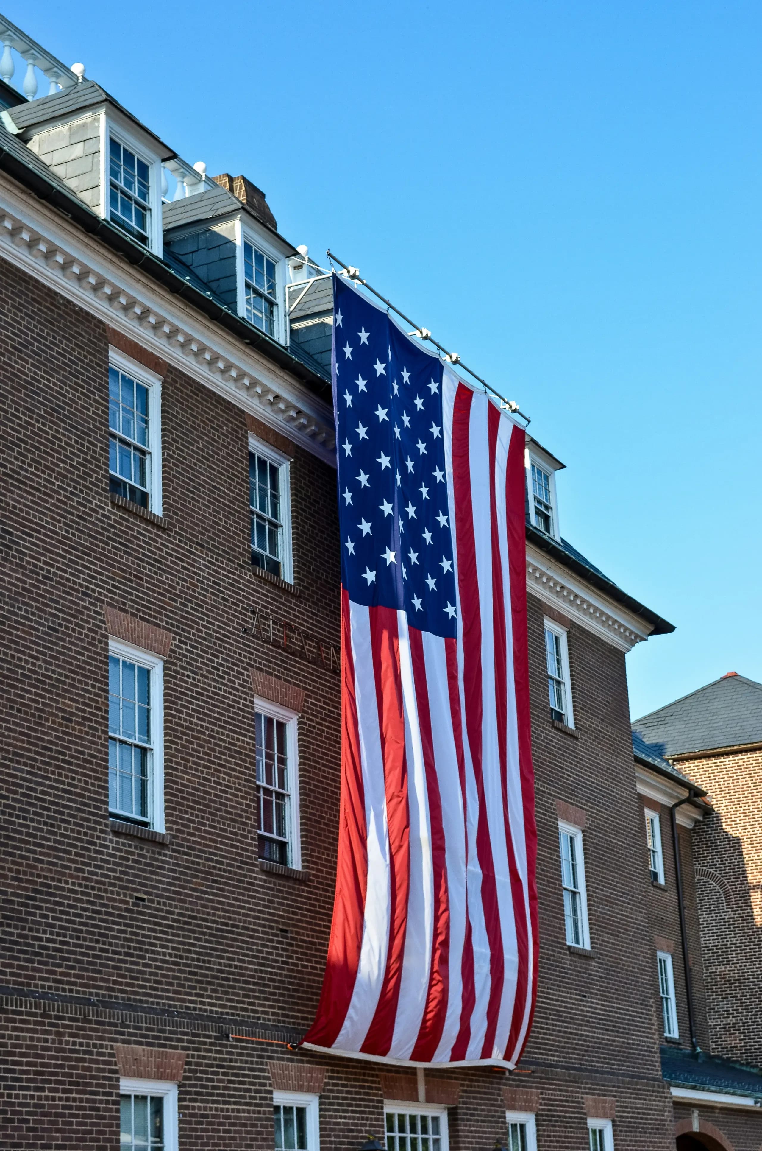 American flag hanging on the side of a brick building